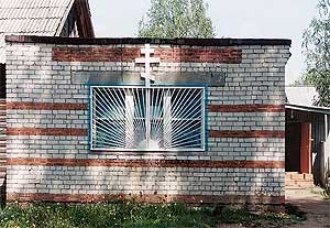 На месте храма с 1999 года стоит деревянный крест. Пока служба идет в этом кирпичном здании.